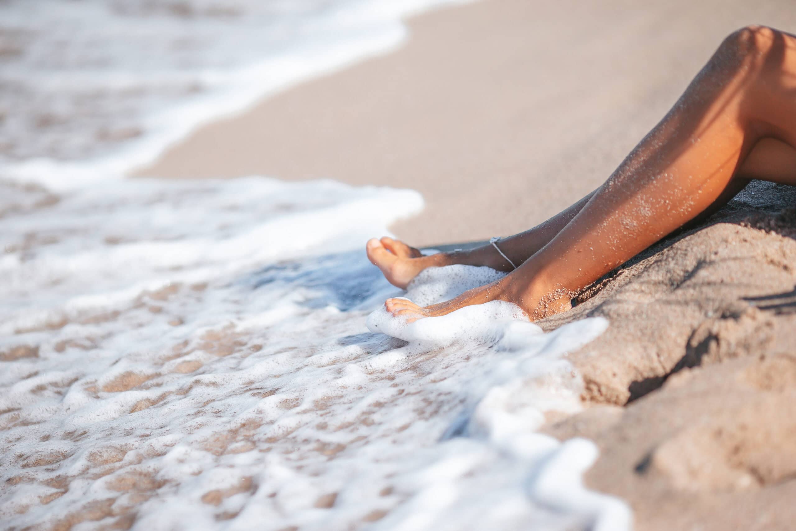 Closeup of woman legs splashing in shallow water on the beach Hausarzt Praxis Söchtenau - Leistung - Dermatologie